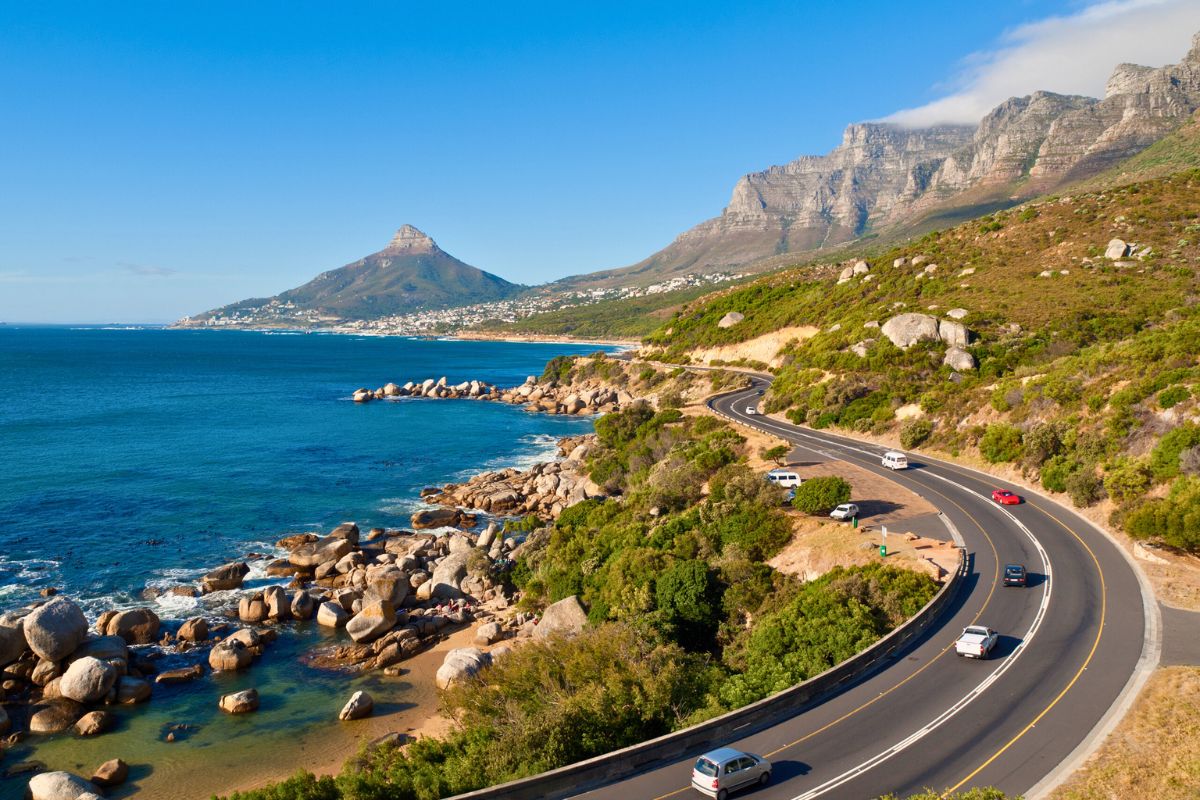 Cars wind along the scenic road between the mountains and the sea, sparking a list of things to do in Cape Town