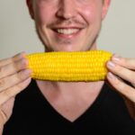 a person holding corn in hands representing maize starch vs corn flour