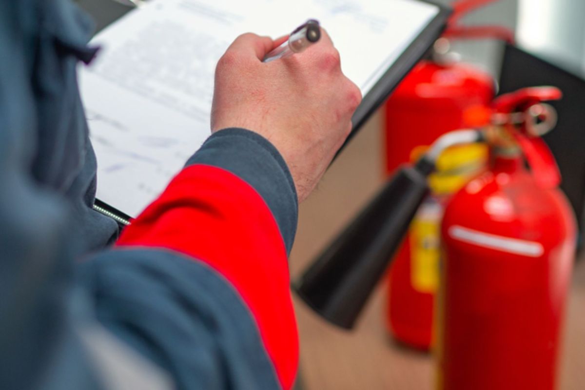 a person doing pat testing and fire extinguisher safety check