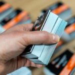 a person holding multiple business card in his left hand
