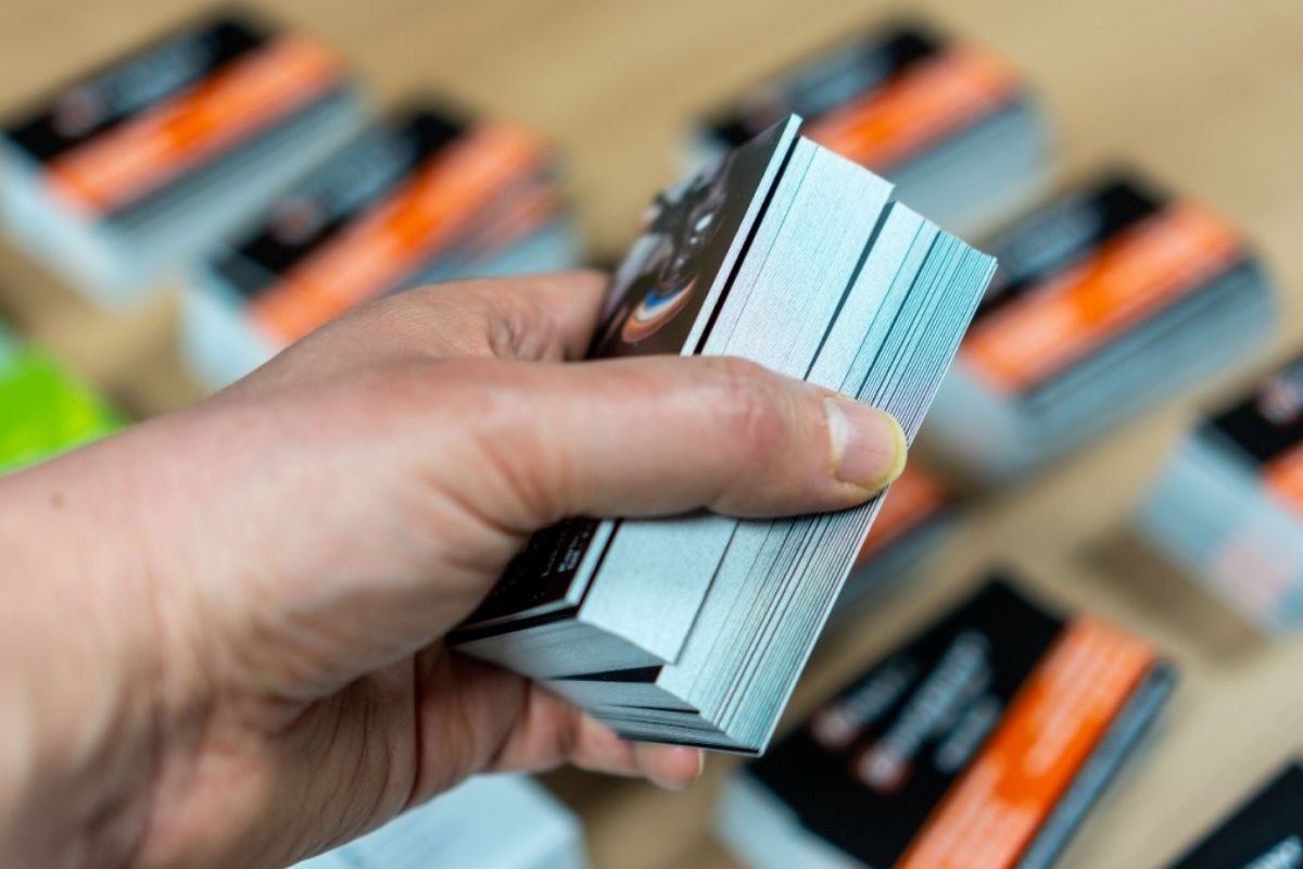 a person holding multiple business card in his left hand